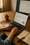 Hands typing on a laptop displaying analytics charts and traffic data at a warm-lit desk