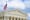 Front view of United States Supreme Court Building in Washington DC with flag in forefront