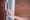 Close-up of a woman's hand pressing the button on a smart doorbell with voice and cam