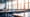 A blurred view of an empty school classroom with sun coming through windows.