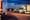 Several trucks parked at night at a rest stop.