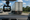 A dashcam mounted on the inside windshield of a passenger vehicle on the highway with cars and semi-truck.