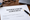A sample nondisclosure agreement on a desk with a pen, glasses, laptop and corner of a book nearby.