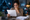 Worried woman reading a data breach notice at home, surrounded by digital security warning icons.