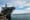 Military navy ship in the port. Gray modern warship with blue sky in the landscape sea. 