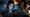 Teen using a smartphone with facial age verification graphics while a concerned parent looks on.