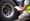 Truck inspector wearing a yellow safety vest holding a clipboard, pen and marking a form while checking semi truck tires.