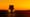 View of the front of a semi-truck driving on interstate freeway at stunning sunset.