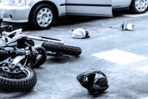 Helmet and motorcycle on the street after car crash
