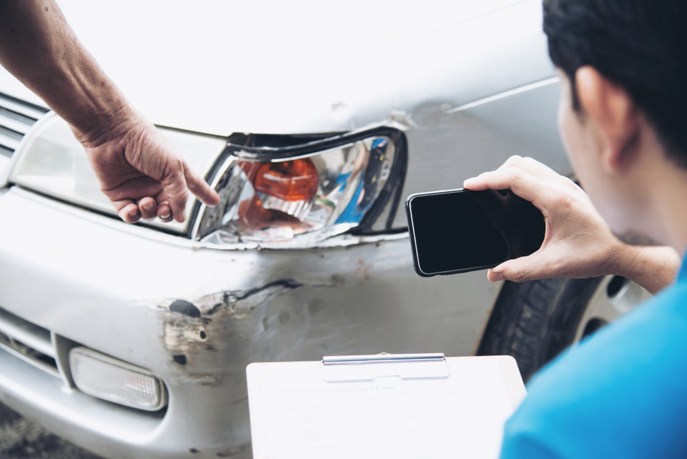 Don’t Believe These 4 Myths When It Comes to Your Car Accident Claim Insurance agent working during on site car accident claim process