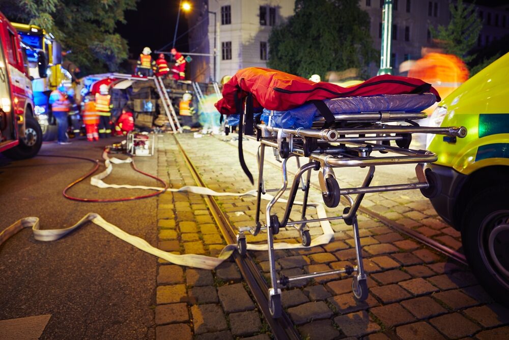 car accident scene at night with emergency services on site with a stretcher in the foreground