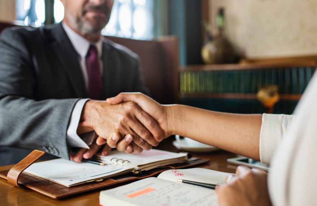 Close-up of two business people shaking hands over a desk