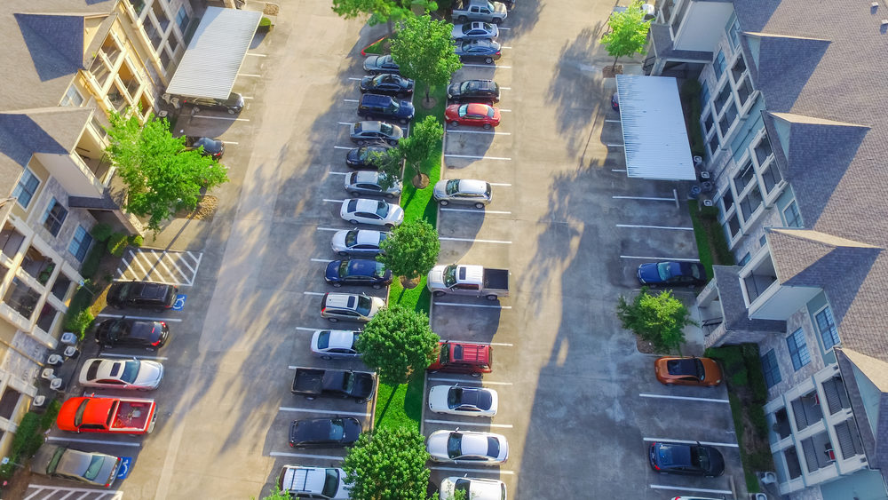 Aerial view of cars parked in a parking lot at apartment building