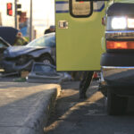 ambulance in forefront with cars crashed on the road behind