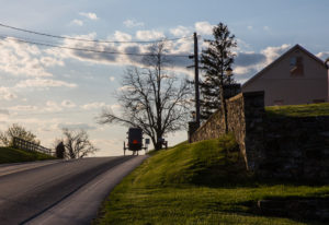 Amish buggy traveling up a road in rural Lancaster County Pennsylvania.