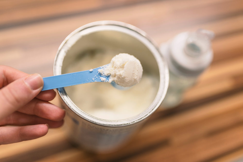  Milk powder for baby in measuring spoon on can.