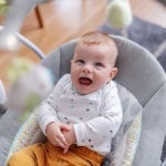 Adorable caucasian 6 months old baby boy sitting in his rocker chair