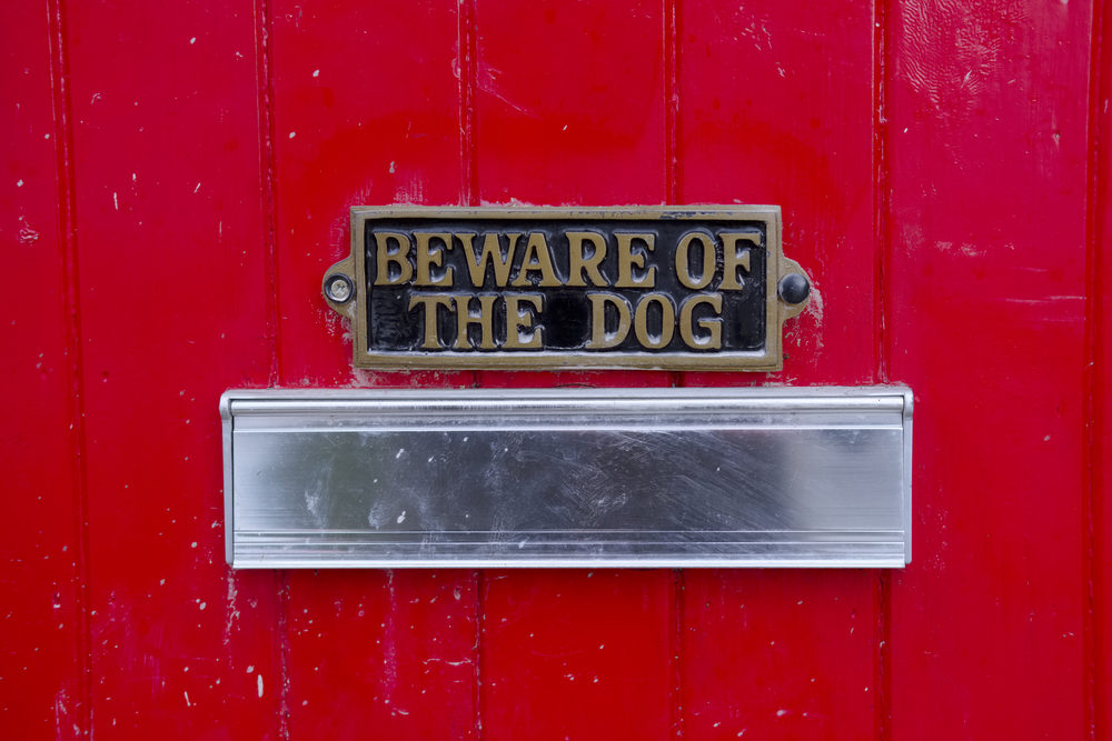 Beware of dog sign on front gate of house above letter box