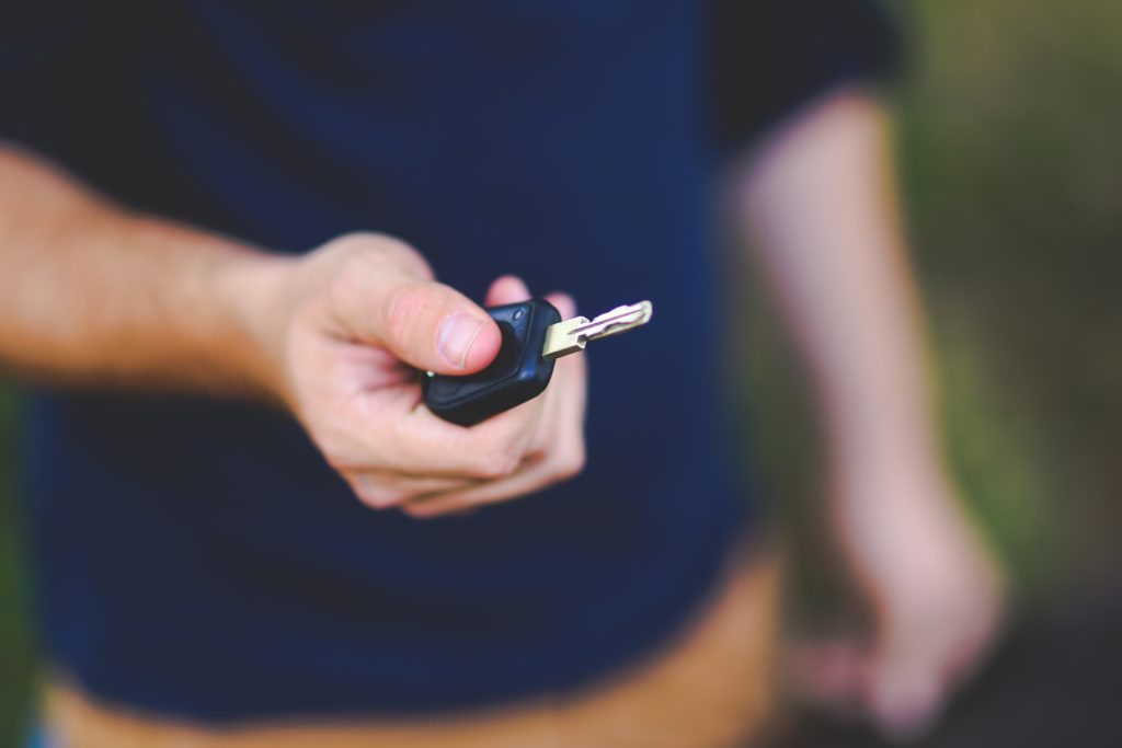 A man presses a button on a key fob