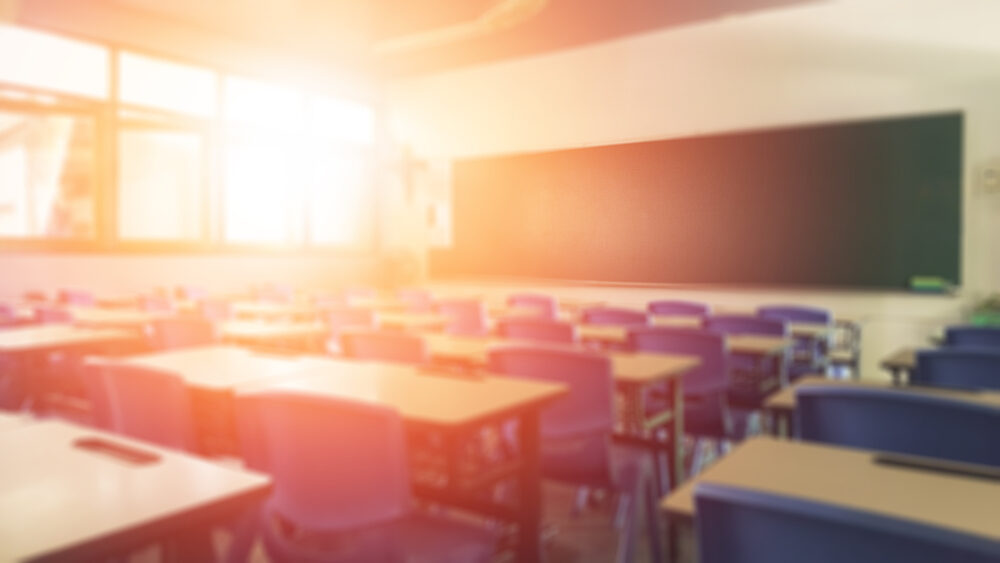 blurred view of elementary school classroom with sunlight shining through window
