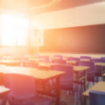 blurred view of elementary school classroom with sunlight shining through window