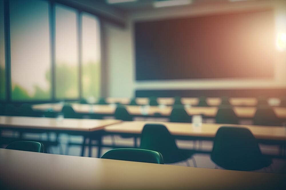 Former Gwinnett County School Teacher, Blake Edwards, Facing Child Sex Exploitation Charges for Possessing and Sharing CSAM Blurred school classroom without students with empty chairs and tables.