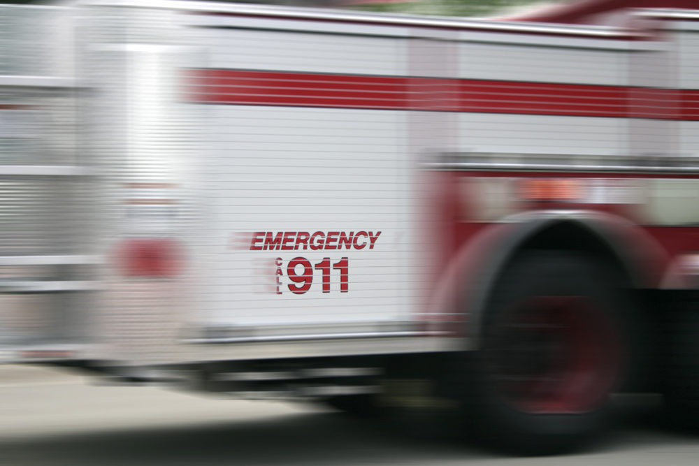 Runaway Truck Smashes Into Fresno Bank to Injure Six People blurred view of an emergency vehicle with call 911 on the side