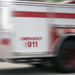 blurred view of an emergency vehicle with call 911 on the side
