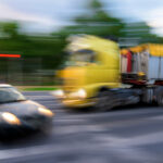 Dangerous traffic situation between a car and a truck in motion blur.