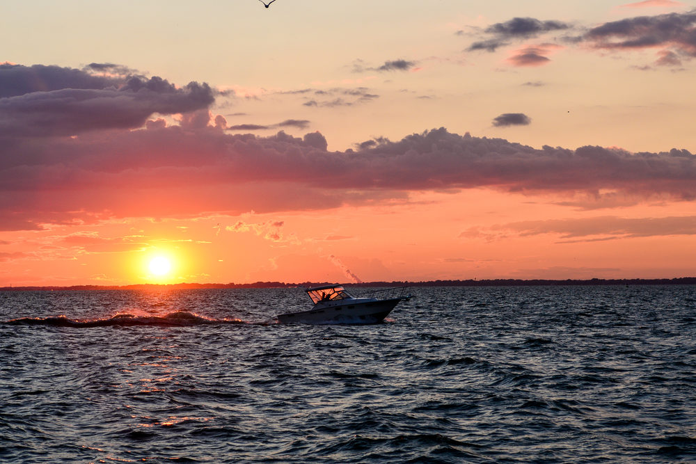What Are the Dangers of Reckless Boating in Ohio? a boat crossing the sunset in Sandusky bay On Lake Erie