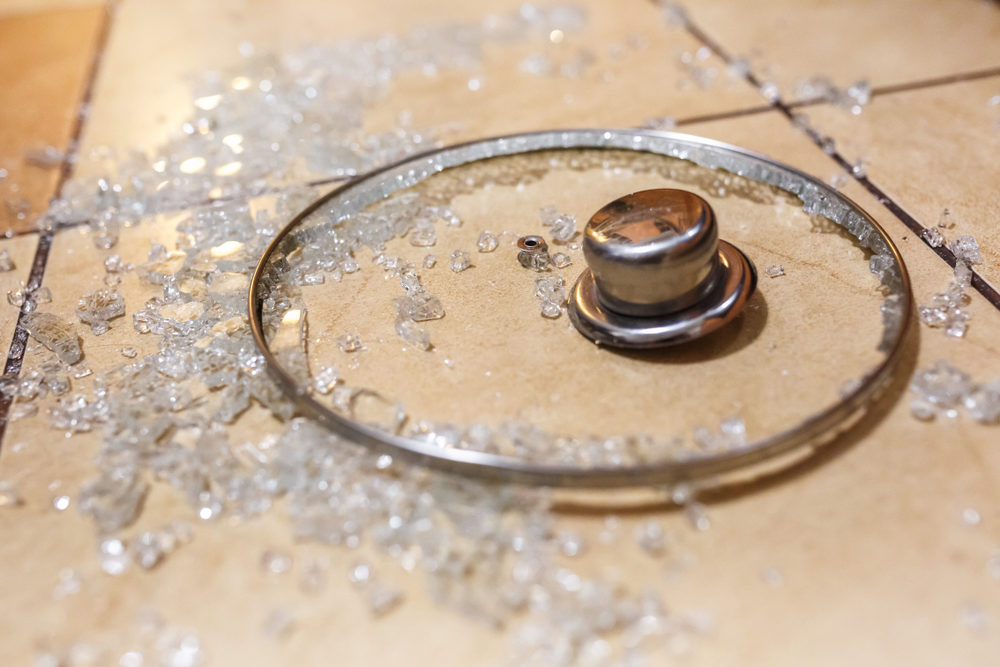 Broken glass lid on the ceramic tiles floor.