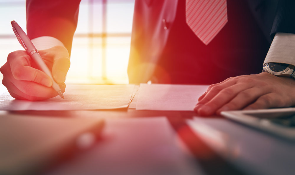 Close up businessman signing documents.