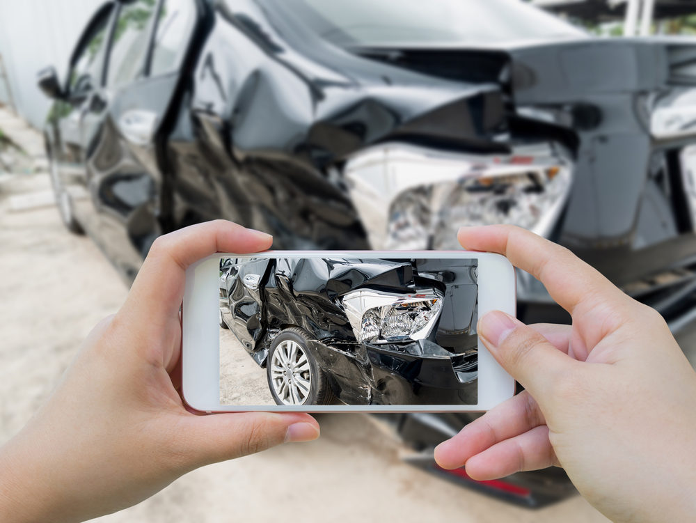 Car crash accident damaged with hand using smartphone taking photo