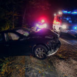 car crashed off roadway with police and emergency services.