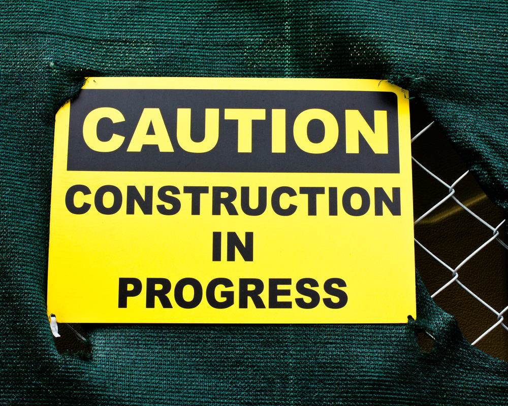 Box Truck Collision Causes Scaffolding Collapse West 29th Street in Chelsea, Injuring Three People, One in Critical Condition Caution sign at a construction site