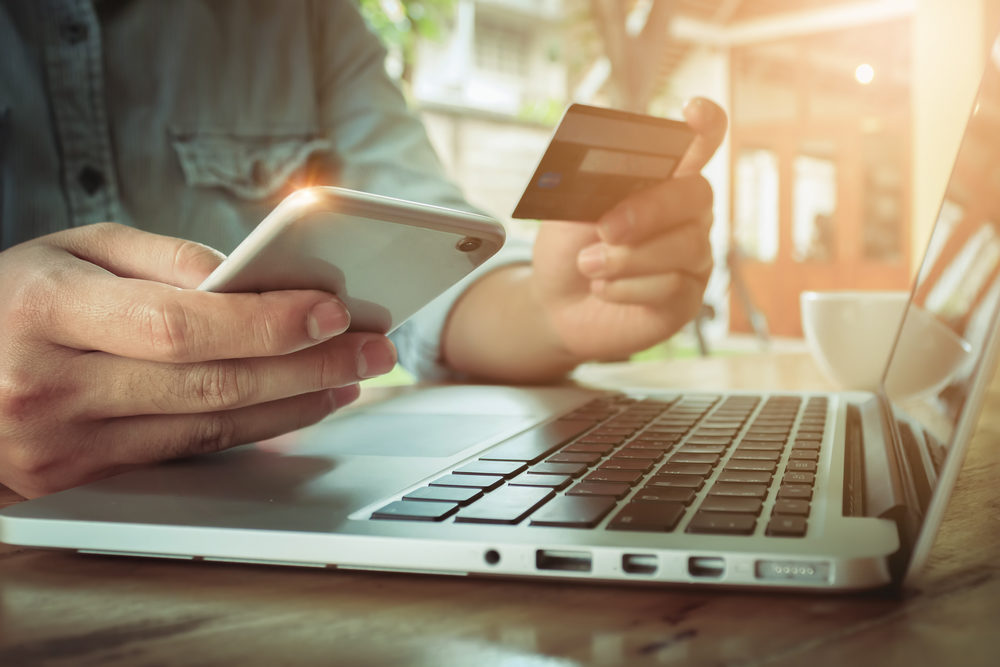 Online payment,Man's hands holding smartphone and using credit card for online shopping.