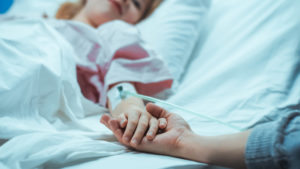 Recovering Little Child Lying in the Hospital Bed Sleeping, Her Hand Falls into Mother's and She Holds it Comfortingly.