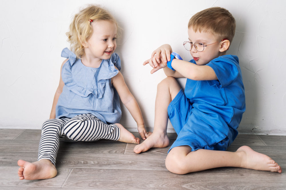 Wild Republic Recalls Over 460,000 Slap Watches for Choking Hazards A little boy child in a blue T-shirt and glasses shows the girl his smart watch and presses a finger.