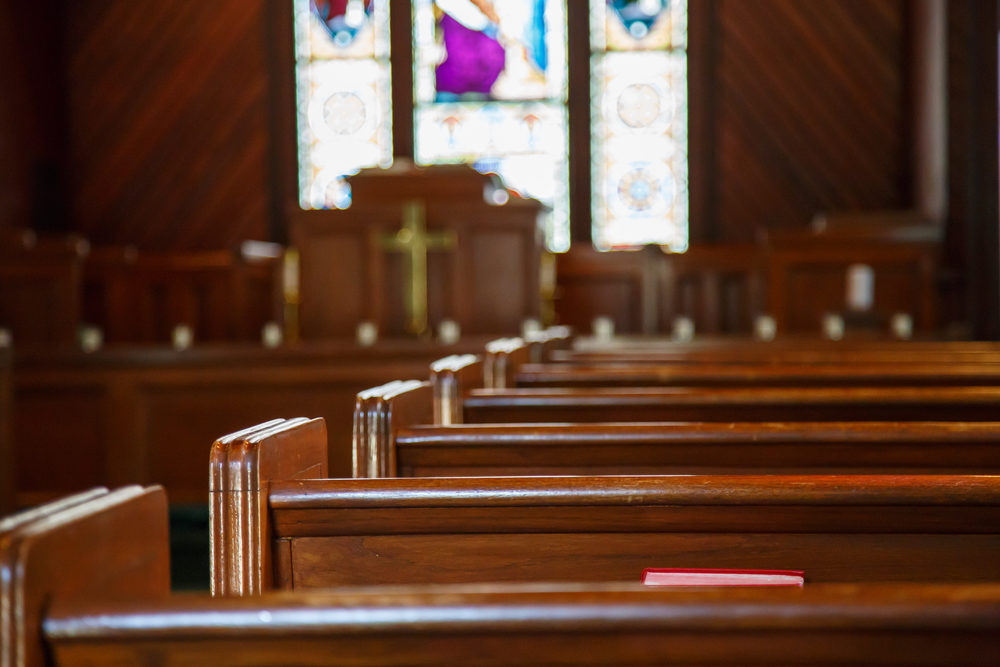 Stained glass windows in small church with wood pews