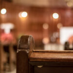 back view of an interior church pew with blurred background