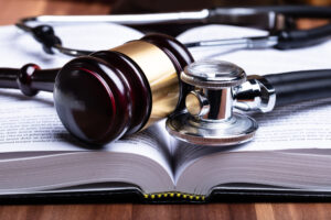 closeup of a gavel and stethoscope laying on an open book