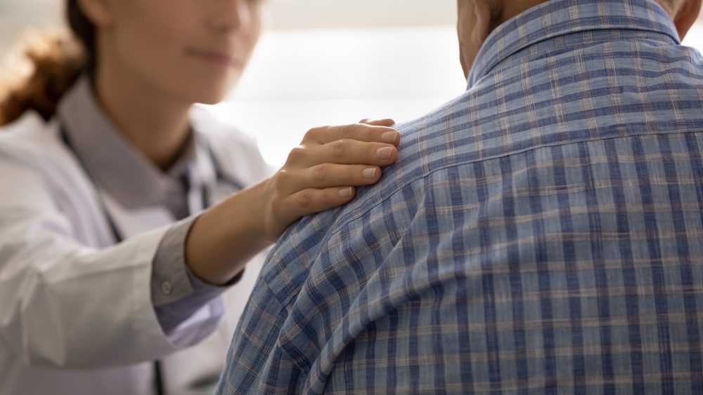 female doctor consoling an elderly male patient after bad news