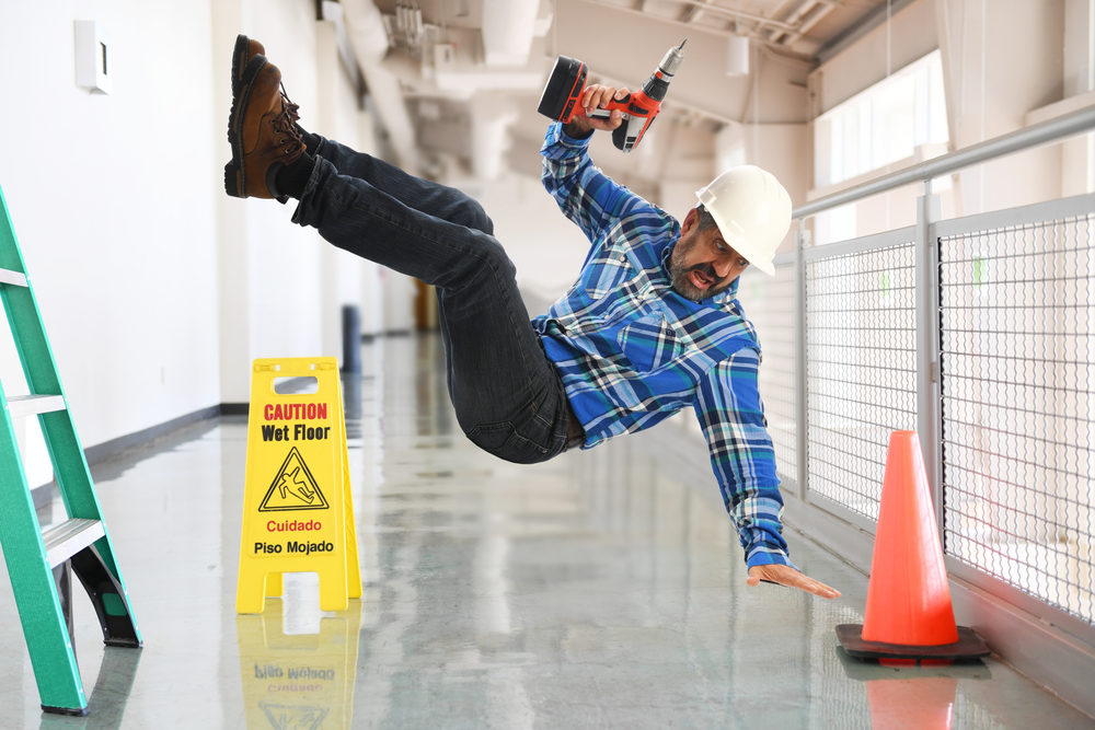 Male construction worker falling off a ladder inside a building