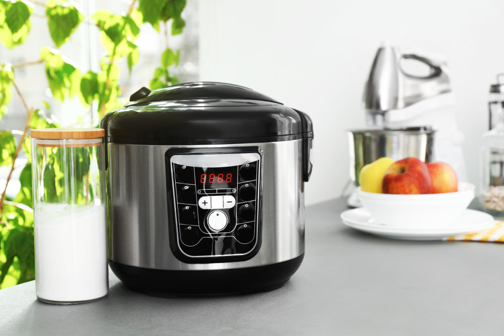 Instant Brands Settles Pressure Cooker Lawsuit with Mother of Injured Child New modern multi cooker and jar of flour on table in kitchen.