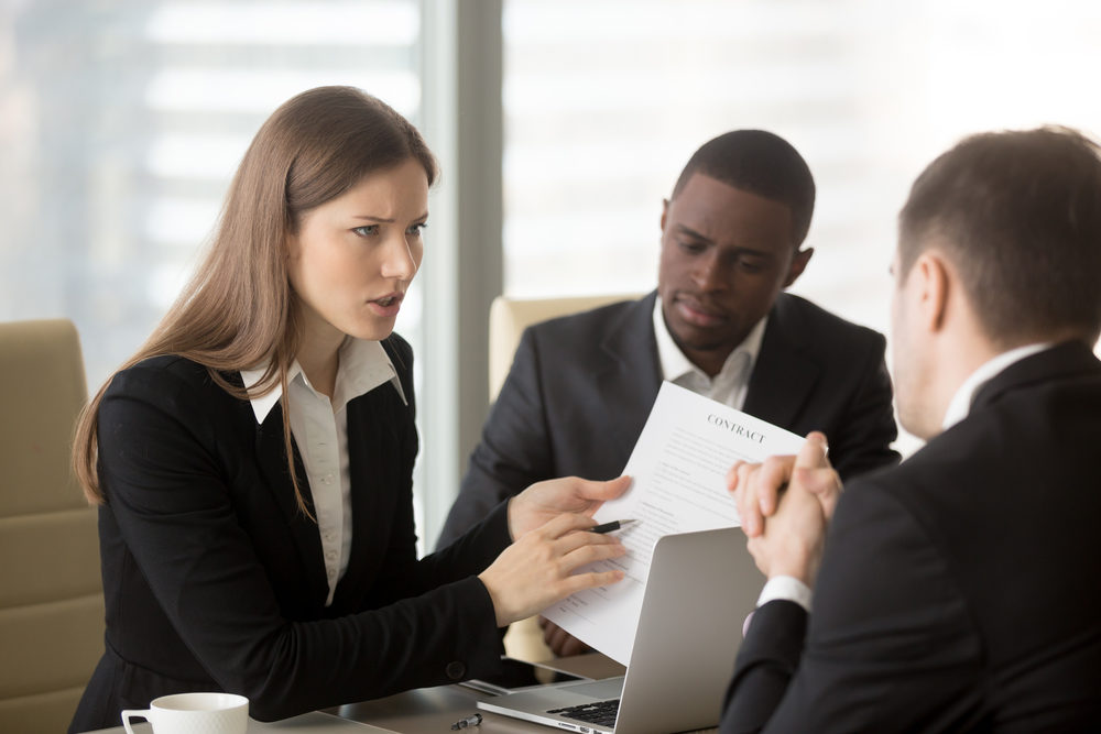 Angry dissatisfied businesswoman holding contract arguing with contractor, pointing at terms failed to perform, demanding termination, loss compensation, defrauded cheated investor protecting rights