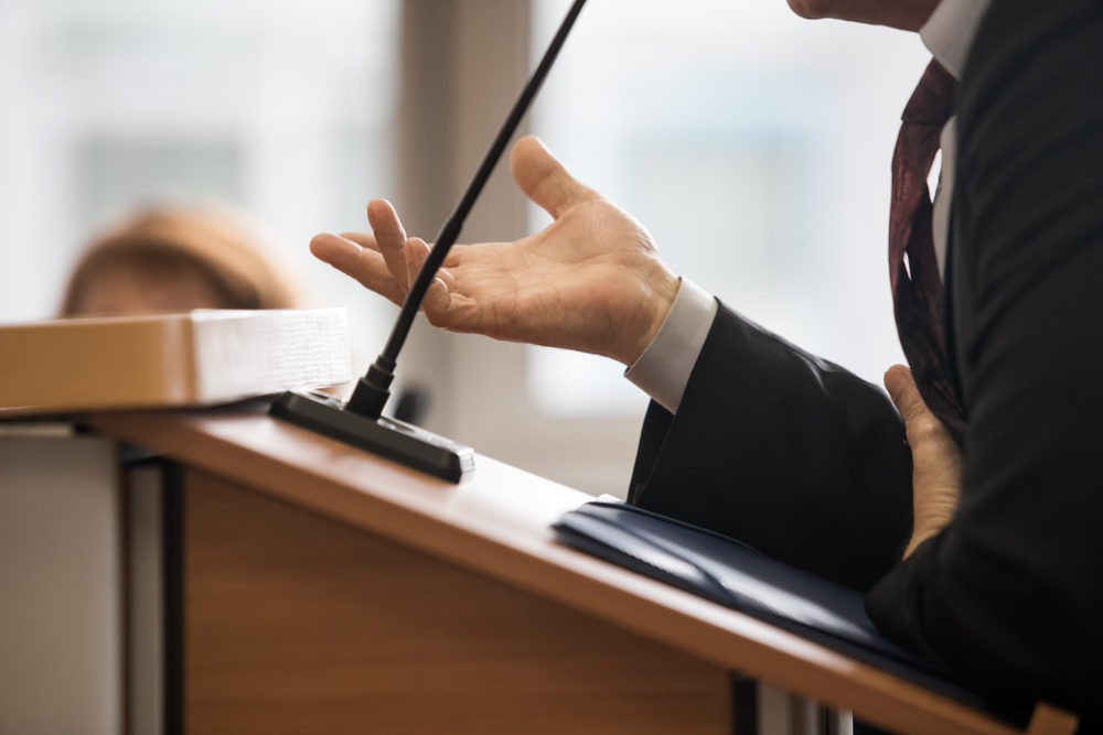 male lawyer speaking in courtroom at podium