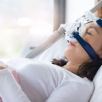 Senior woman using cpap machine to stop choking and snoring from obstructive sleep apnea