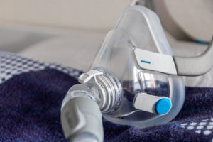 cpap mask on a blanket on a bed