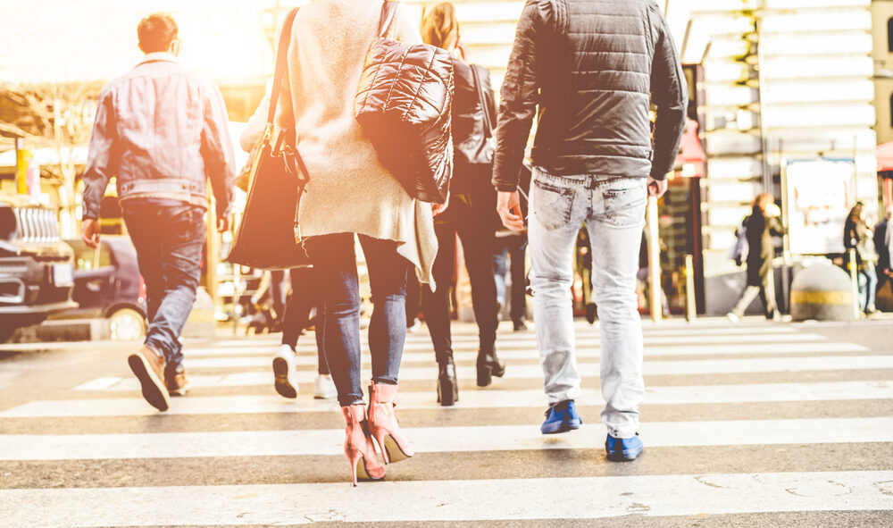 rear view of a crowd of pedestrians walk at a crossing