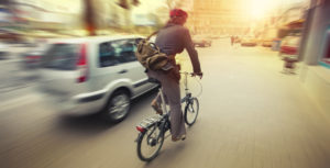 male cyclist in traffic on a city roadway